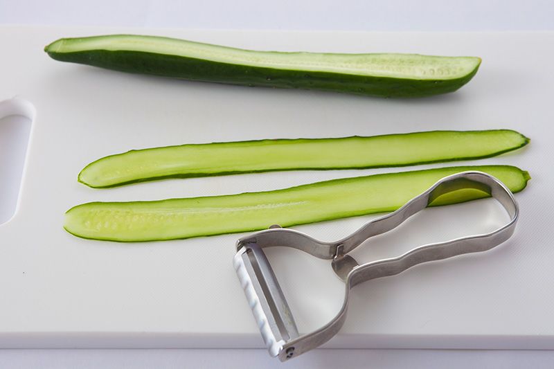 Coupez un concombre en fines lamelles dans le sens de la longueur, à l’aide d’un épluche légumes.