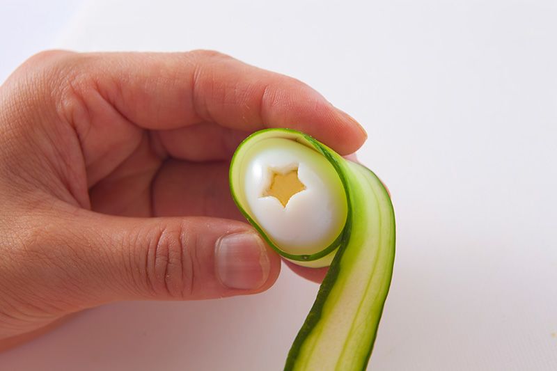 Enroulez une lamelle de concombre autour de l’œuf.