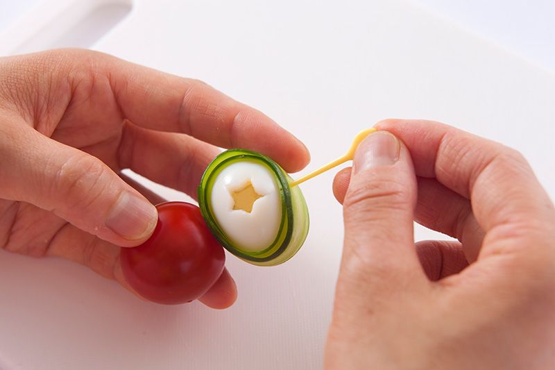 Enfilez l’œuf et une tomate cerise sur un cure-dent.