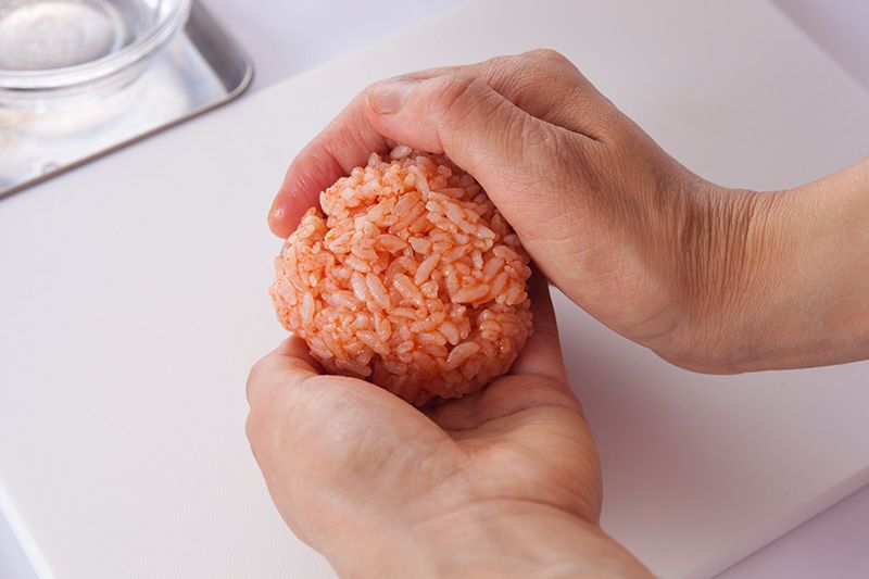 Faites une boulette avec du riz frit au poulet assaisonné de ketchup.