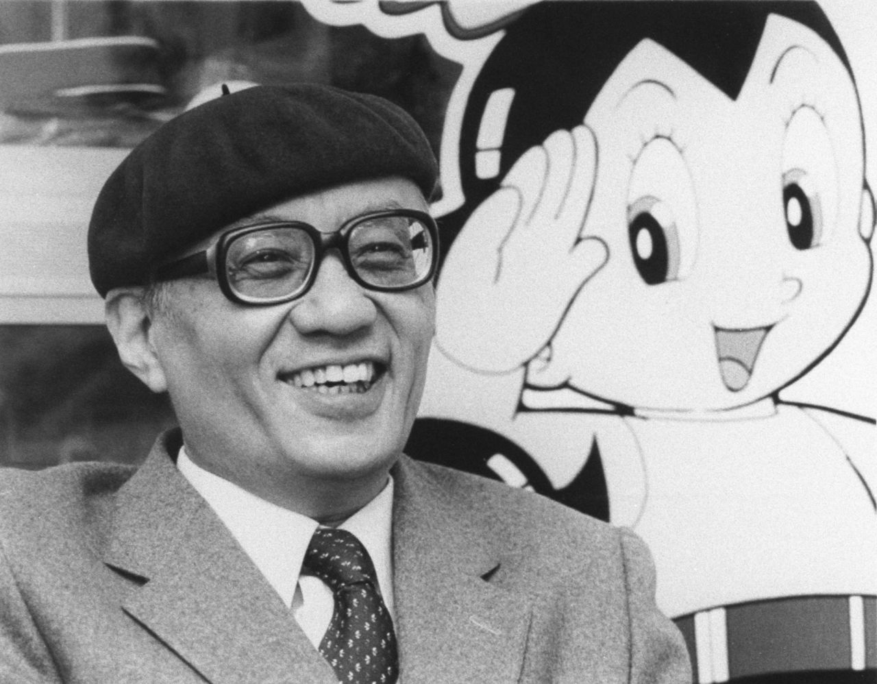 手塚治虫在「原子小金剛」前談話,攝於1985年2月,東京高田馬場(手塚製作公司授權/共同通信社)