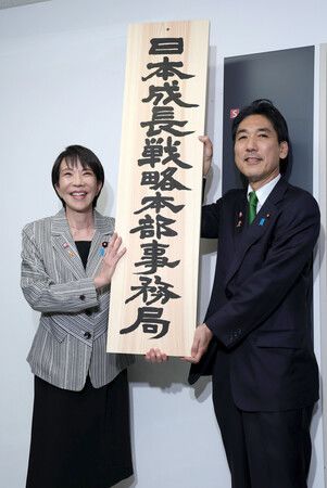 首相高市早苗(左)和日本成長戰略擔當相城內實手持「日本成長戰略本部事務局」的看板合影。攝於4日上午,東京都千代田區(代表攝影)