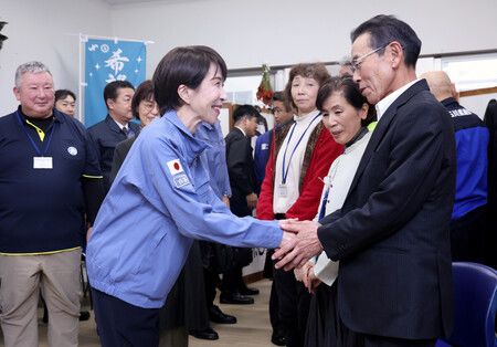 在石川縣穴水町臨時商店街「Anamizu Smile Marche」舉行意見交流會後,首相高市早苗(前排左)與當地相關人士握手。攝於7日下午(代表攝影)