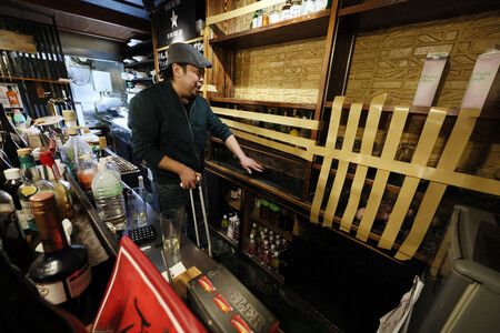 居酒屋店員正在清理散落一地的餐具。他們用膠帶加固瓶子和玻璃杯,防止再次掉落。攝於9日下午,青森縣八戶市