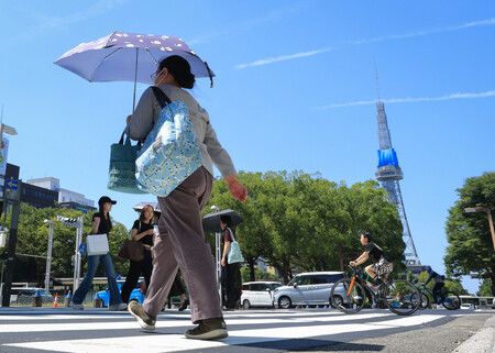 烈日下撐傘行走的民眾。攝於23日下午,名古屋市中區