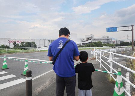 一對父子在永旺夢樂城熊本前默哀祈福。(4日下午,熊本縣嘉島町)