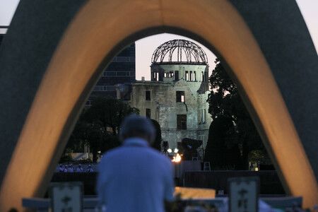 原爆投下81週年,民眾在廣島和平紀念公園原爆死難者慰靈碑前祈禱,後方為原爆圓頂館