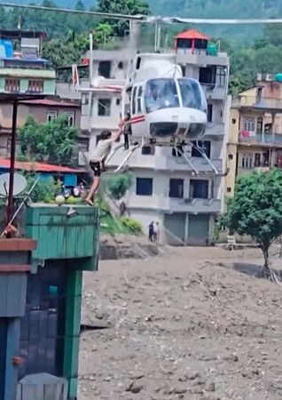 26日,尼泊爾與中國西藏自治區邊境附近,尼泊爾軍方直升機救援一名年輕男子(尼泊爾軍方提供、法新社時事)