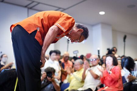 玉城丹尼(前)在確定敗選後,向聚集在會場的支持者鞠躬致意。13日晚間攝於那霸市