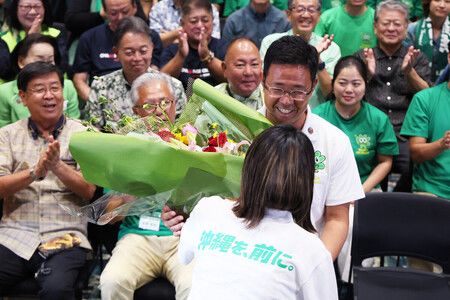 沖繩縣知事選舉確定當選後,古謝玄太(前排右2)笑著接受花束。13日攝於那霸市