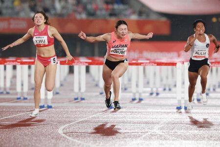 愛知名古屋亞運田徑女子100公尺跨欄決賽,日本選手福部真子(中央)率先衝過終點。27日攝於愛知縣Paloma瑞穗體育場。(法新社/時事通信社)