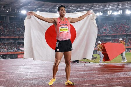 日本選手丸山優真贏得田徑男子十項全能金牌後高舉日本國旗。27日攝於愛知縣Paloma瑞穗體育場。(法新社/時事通信社)