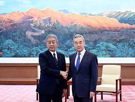 28日,日本前外相岩屋毅(左)在北京與中共中央政治局委員兼外交部長王毅握手。(取自中國外交部官網)