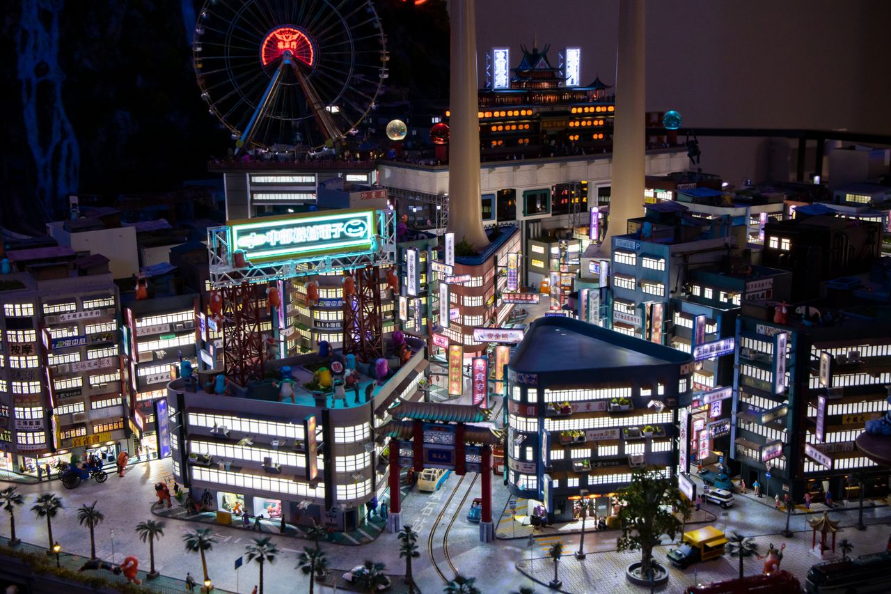 أضواء النيون تتلألأ في إعادة لتجسيم مصغر لمشهد من أحد الأحياء النابضة بالحياة الليلية في الصين.