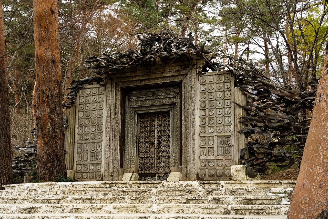 يتميز المدخل الرئيسي للمتحف بباب خشبي منحوت اشتراه إتشيكو في زيارة إلى الهند. موساسابي، السناجب الطائرة اليابانية، تعشش في الفروع على طول الجزء العلوي من الإطار