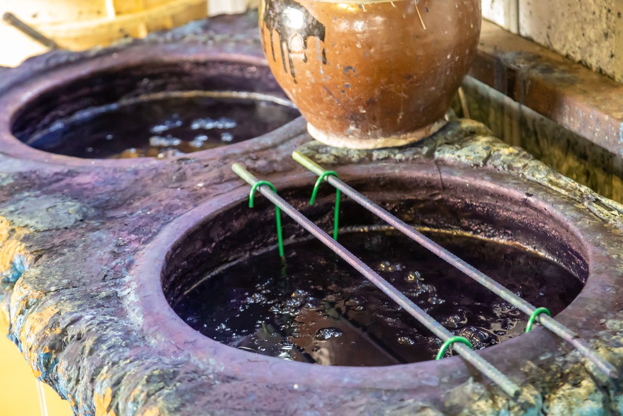 ينقع القماش في وعاء يحتوي صبغة النيلة.© بيكستا.