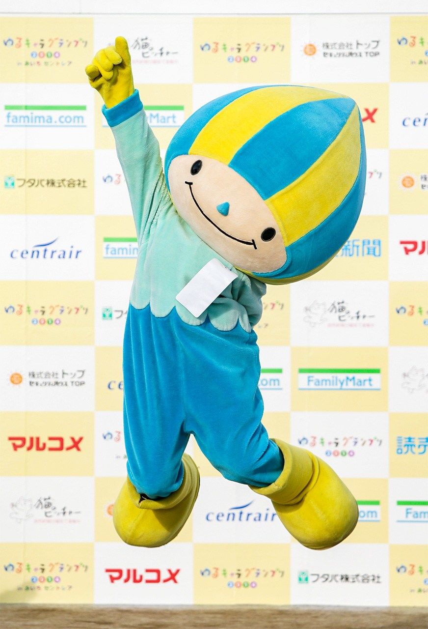 مينامو التميمة الرسمية لمحافظة غيفو وهي مستوحاة من شكل جنية المياه. يمثل اللون الأزرق على الملابس الممرات المائية النقية في المحافظة والأصفر يمثل وفرة أشعة الشمس (© جيجي برس)