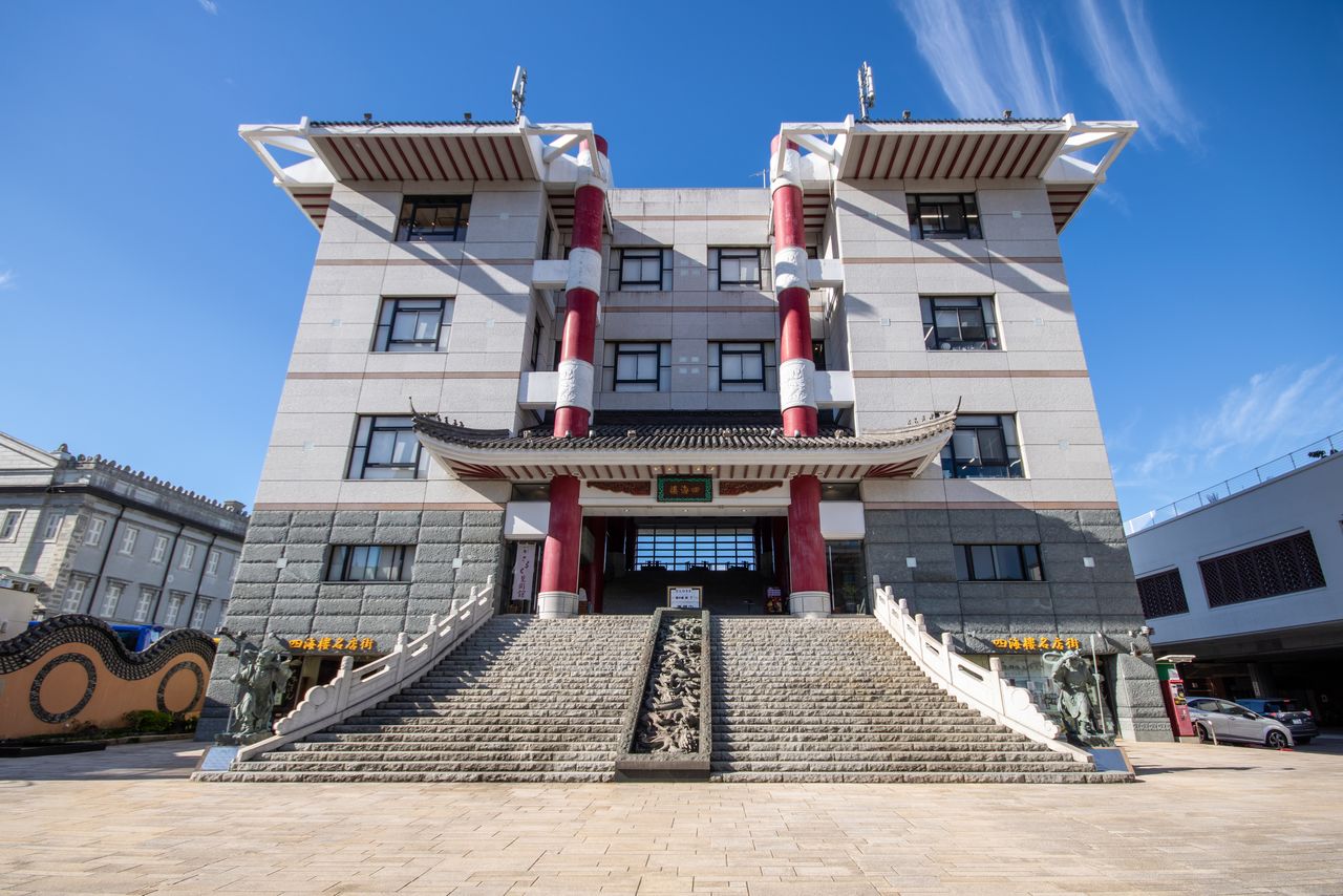 المتجر الحالي يتميز بأعمدة قرمزية بارزة تتباين مع واجهته الحجرية البسيطة (© Nippon.com)