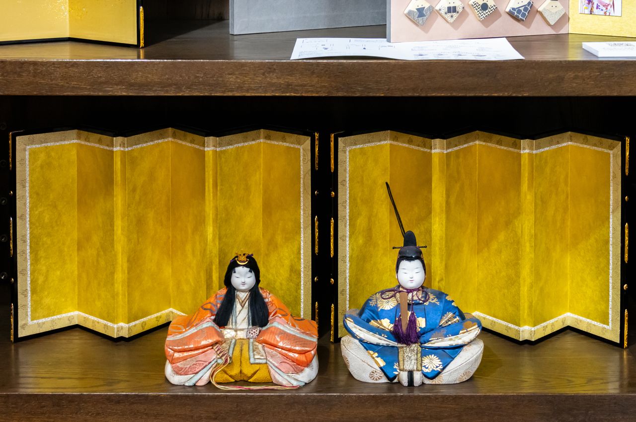 دُمي الزينة ”هينا“ معروضة أمام إحدى السواتر القابلة للطي. (© Nippon.com)