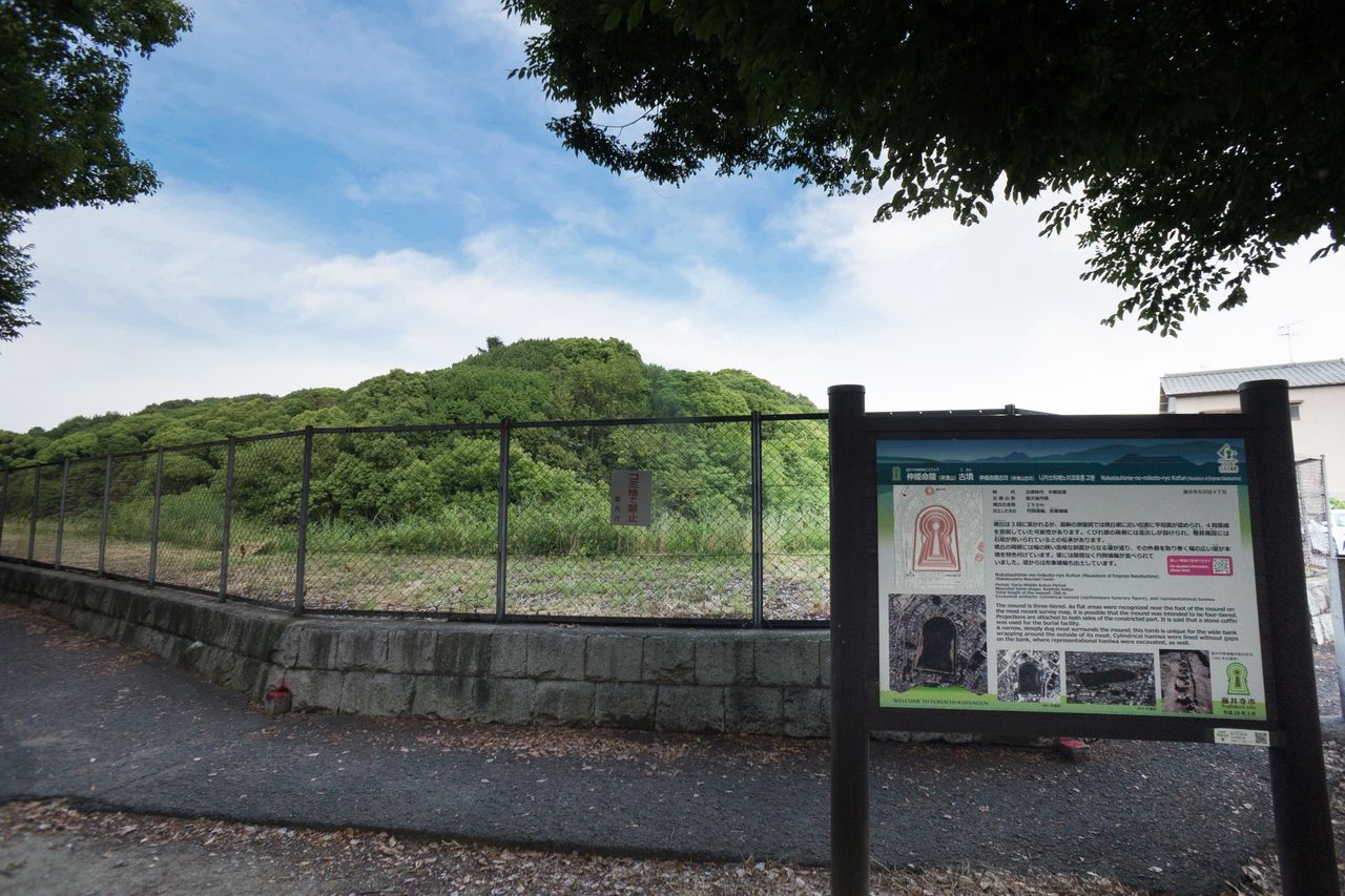 لوحة إعلانية إلى الجنوب الغربي من تلة الدفن ناكاتسوهيمي نو ميكوتو تحتوي على معلومات حول حجم المقبرة والتاريخ وفولكلور الموقع.