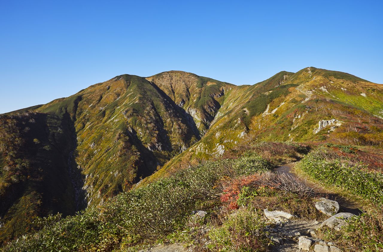  اساهي داكي (في الوسط)، يبلغ ارتفاعه 1871 متر، وهو أعلى قمة في جبال أساهي. بإذن من جمعية السياحة في ياماغاتا.