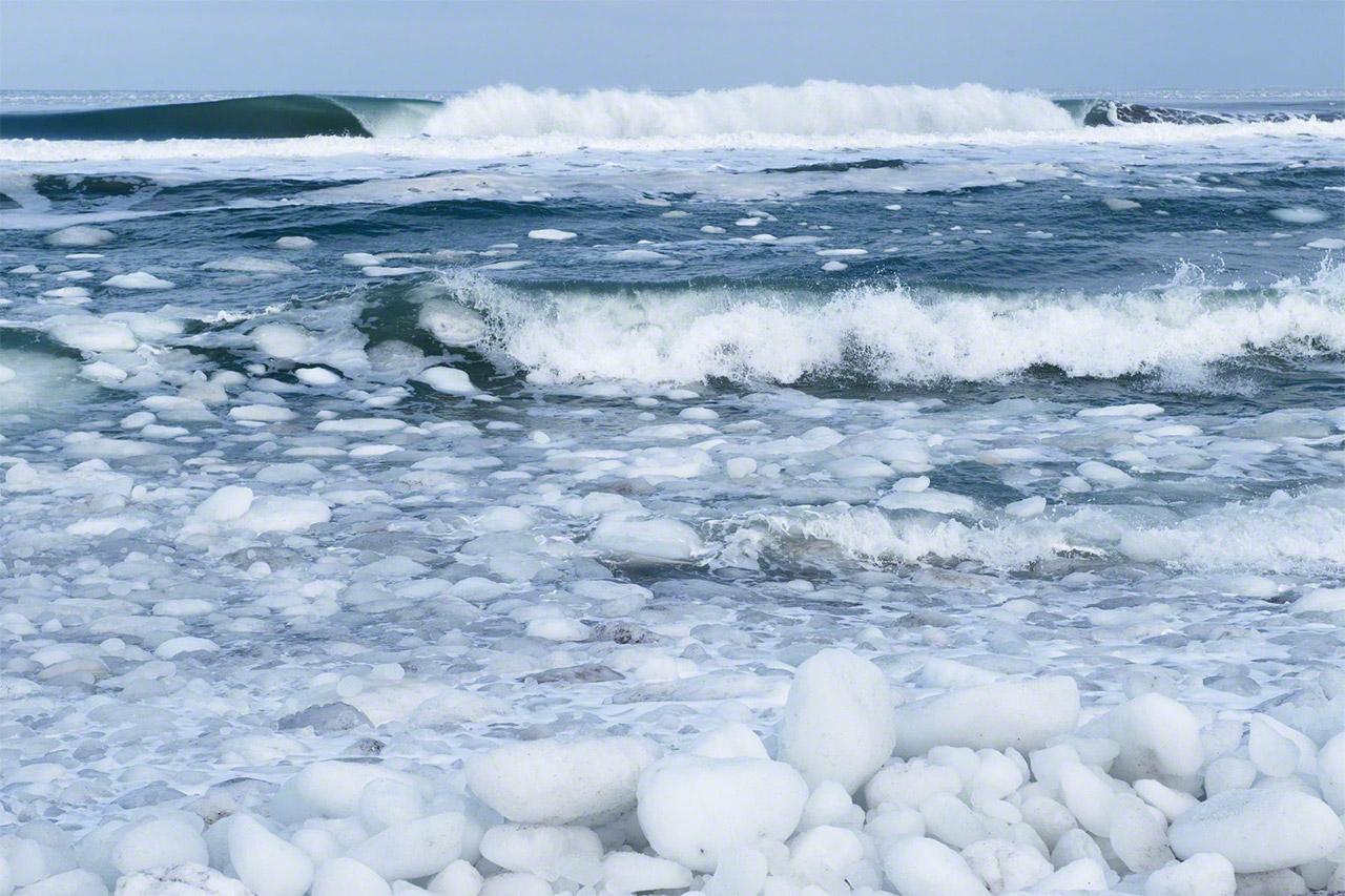 يمكن رؤية قطع الجليد العائم التي تقودها الأمواج العاتية قبل رسوها في الشاطئ.