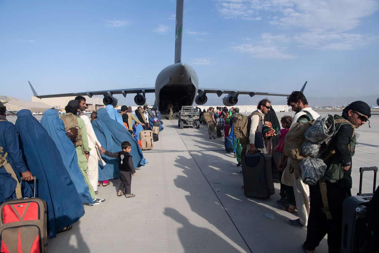 أشخاص يتم إجلاؤهم من أفغانستان في انتظار ركوب طائرة نقل عسكرية أمريكية من طراز C17 (مطار كابول، أفغانستان) (الصورة مقدمة من الجيش الأمريكي) أ ف ب/ جيجي برس.