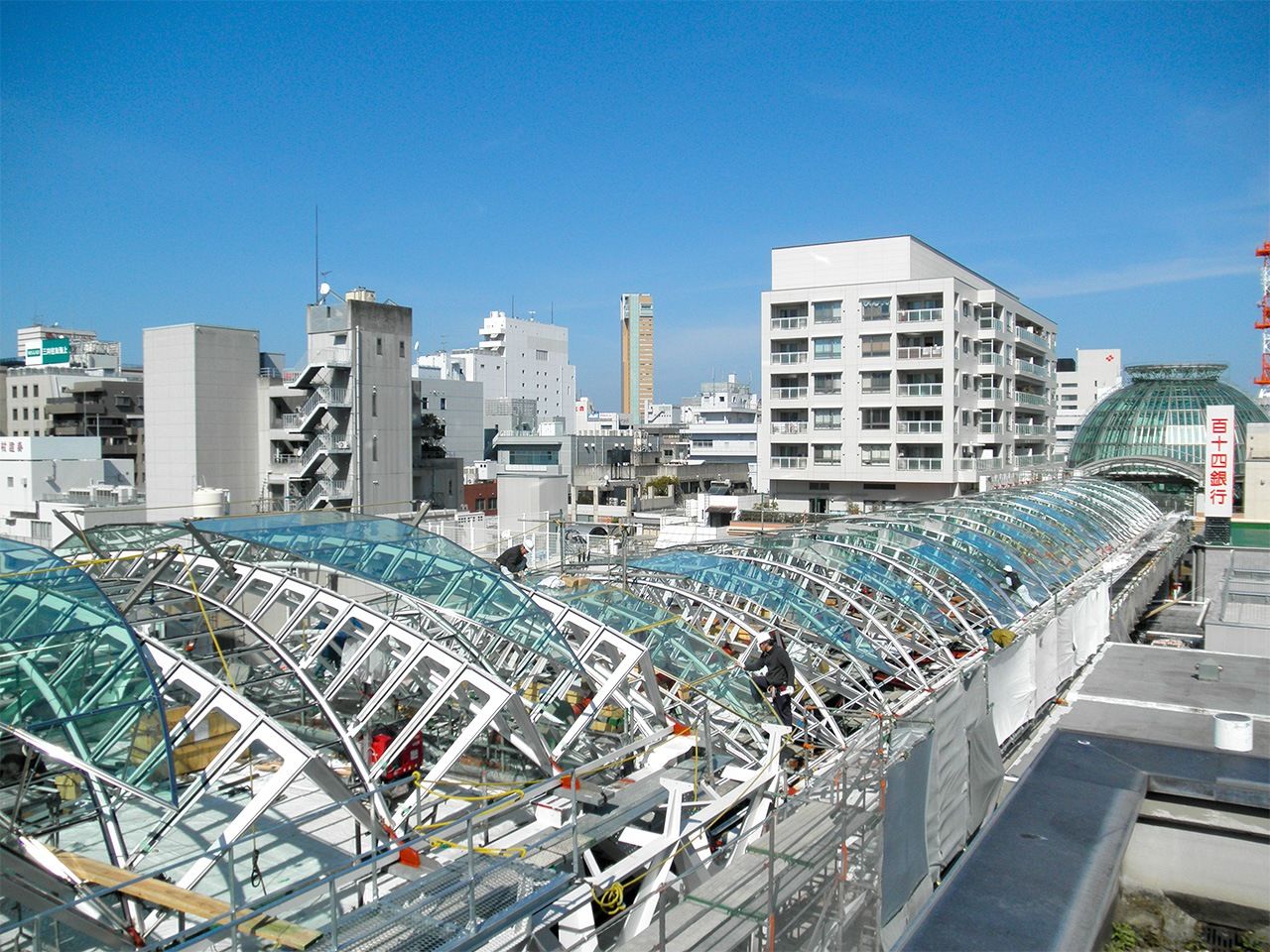 على اليمين، فوق الممرات تقف عمارات تم بناؤها بشكل مشترك من قبل جمعية تعزيز منطقة التسوق تاكاماتسو ماروغامى ماتشي دون التأثير على ملكية الأرض. الصورة من الكاتب.
