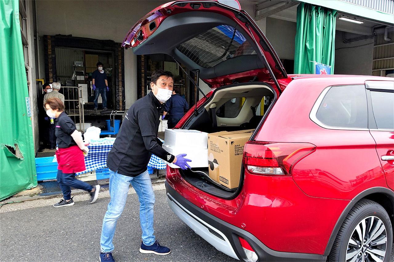 رئيس الشركة مييازاكي ناريتو يساعد في تحميل المشتريات ووضعها بسيارات الزبائن.