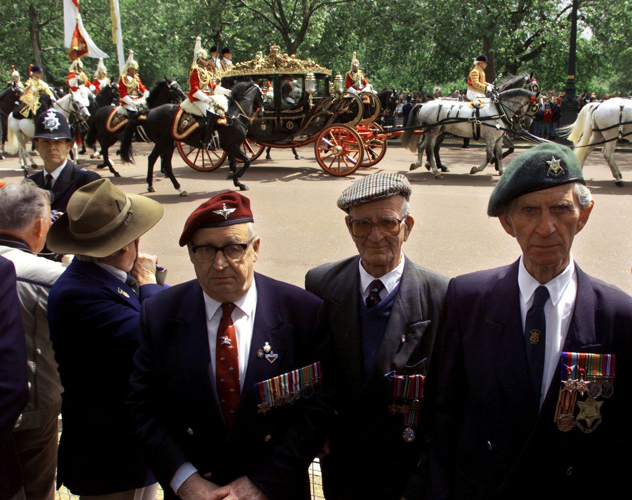 مجموعة من قدامى المحاربين البريطانيين يعطون ظهورهم لموكب الامبراطور الياباني أثناء توجهه إلى قصر باكنغهام في مايو/ أيار 1998 في لندن. © رويترز.