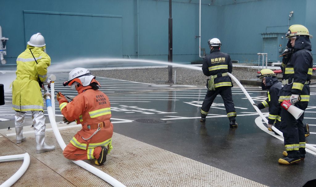 يقوم رجال الإطفاء بإخماد مباني المفاعلات بالماء أثناء تدريب للطوارئ. كيودو نيوز.