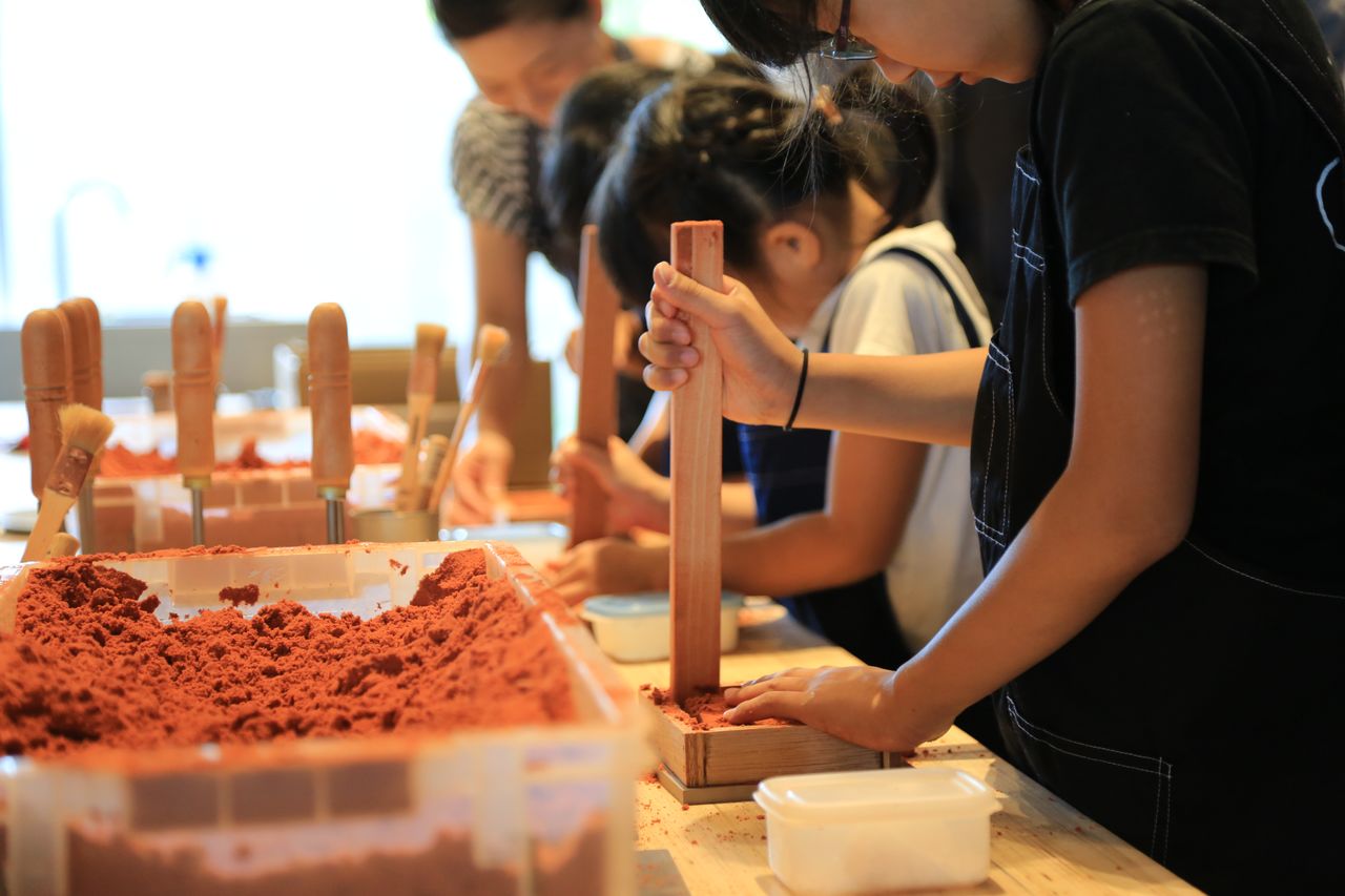 يستطيع المشاركين بالورشة سبك قطعهم الخاصة من القصدير بتشكيلها في قوالب من الرمل.