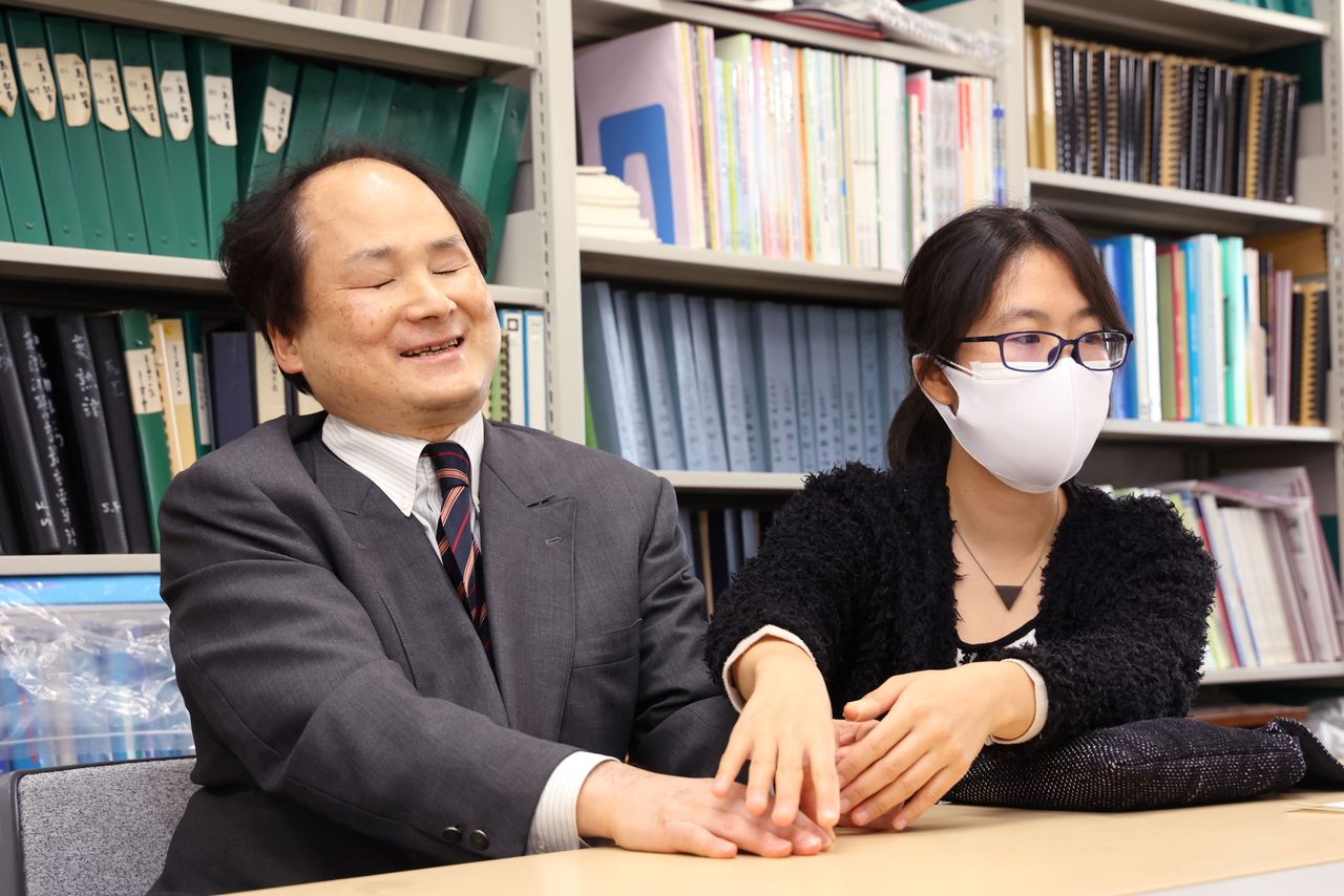 فوكوشيما ساتوشي في مختبره في مركز أبحاث جامعة طوكيو للعلوم والتكنولوجيا المتقدمة. إلى اليمين مايدا أتسومي مترجمة طريقة برايل للقراءة باستخدام الأصابع. (هاناي توموكو)