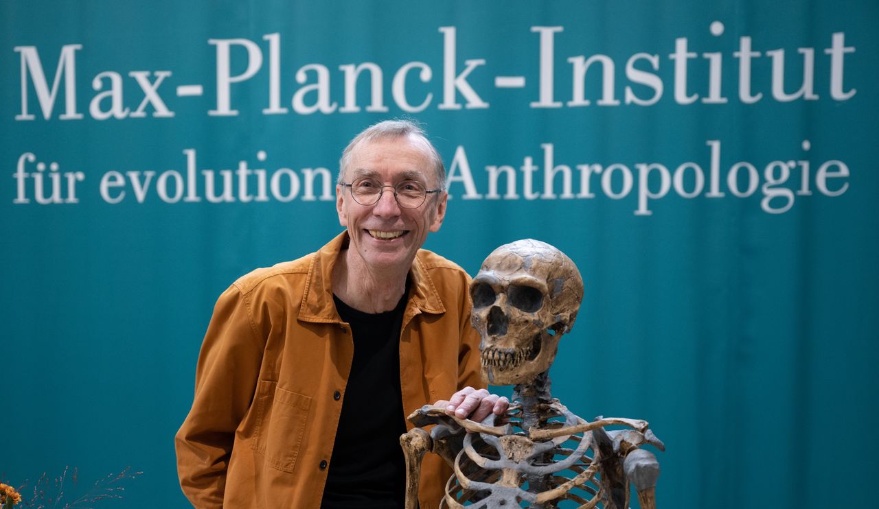 سفانتي بابو يبتسم بجانب نموذج هيكل عظمي لإنسان نياندرتال في معهد ماكس بلانك لعلم الإنسان التطوري قبل مؤتمر صحفي بعد حصوله على جائزة نوبل = تصوير بتاريخ 3/10/2022 (رويترز)