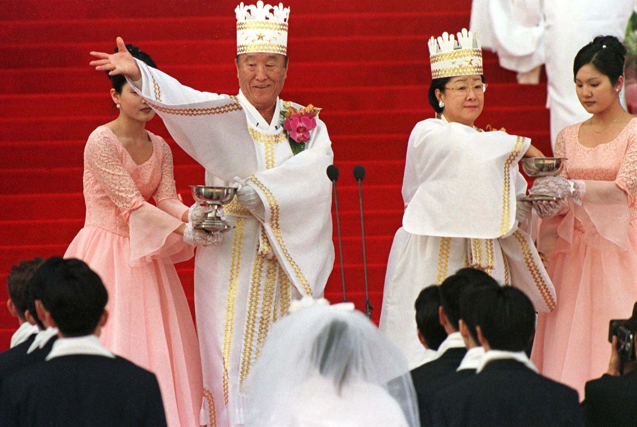 سون ميونغ مون وزوجته يباركان الأزواج في حفل زفاف جماعي لكنيسة التوحيد في سول بكوريا الجنوبية عام 1999 (حقوق الصورة لرويترز).