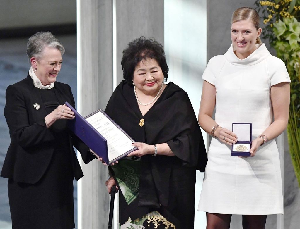 سيتسوكو ثورلو (في الوسط) تستلم جائزة نوبل للسلام نيابة عن الحملة الدولية للقضاء على الأسلحة النووية (ICAN) إلى جانب المديرة التنفيذية للمنظمة بياتريس فين (يمين) في أوسلو في 10 ديسمبر/كانون الأول عام 2017 (حقوق الصورة لكيودو).