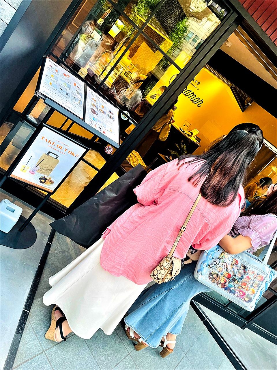  مقهى سينامون يبدو مثل أي مقهى عصري آخر، ولكن زبائنه في الغالب من الأوتاكو الإناث، كما يظهر على النساء اللائي يحملن ”حقائب-إيتا“ عند مدخله. (© هانيؤكا يوري)