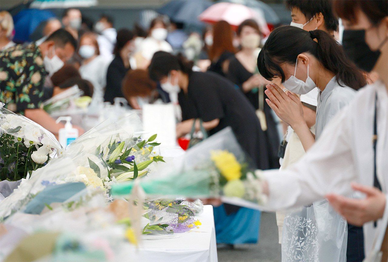 أفراد من الشعب يضعون الزهور ويصلون بعد مقتل رئيس الوزراء السابق شينزو آبي في طوكيو في 15 يوليو/تموز 2022. (© جيجي برس)