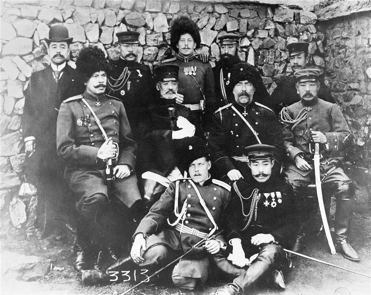 صورة لمسؤولين يابانيين وروس بعد اجتماع الجنرال الياباني نوغي ماريسوكي (الصف الأوسط، الثاني من اليسار) والجنرال الروسي أناتولي ستيسيل (الصف الأوسط، الثاني من اليمين) في 5 يناير/كانون الثاني عام 1905 بعد سقوط لوشون (© جيجي برس).