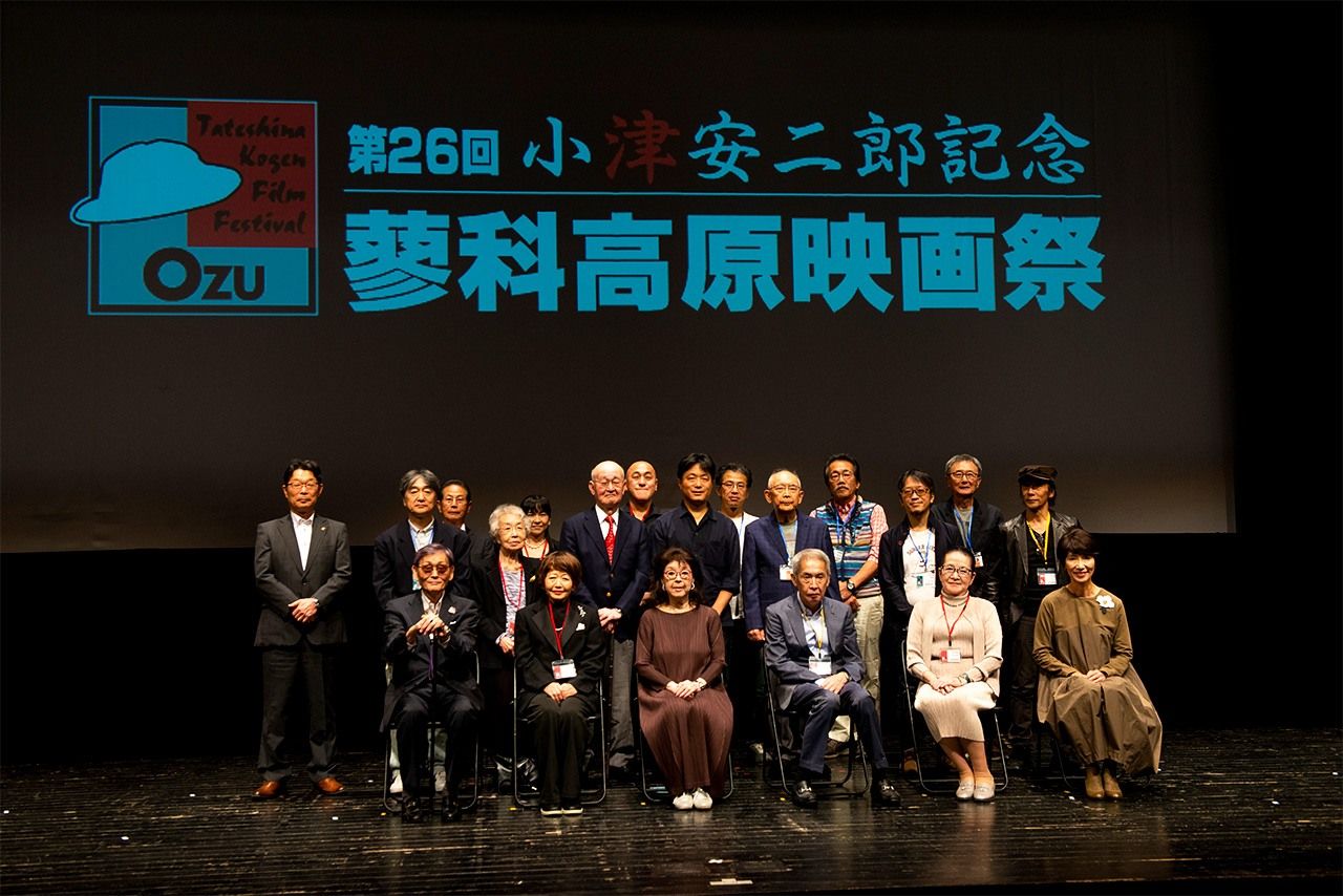 ناغاي هيدييوكي (في الوسط، الصف الثاني) وأكيكو أوزو (الثانية من اليمين، الصف الأمامي) خلال صورة جماعية للمشاركين في مهرجان أوزو ياسوجيرو السينمائي التذكاري في تاتيشينا في سبتمبر/أيلول 2023 (© كوديرا كي)