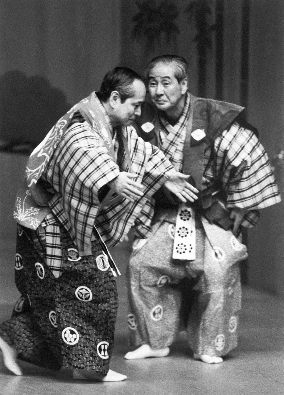أداء الأخوين نومورا مانزو ومانساكو معا في ”هيكوزو (قش الشاي)“ من فن كيوغين على مسرح نو القومي في طوكيو (© جيجي برس)