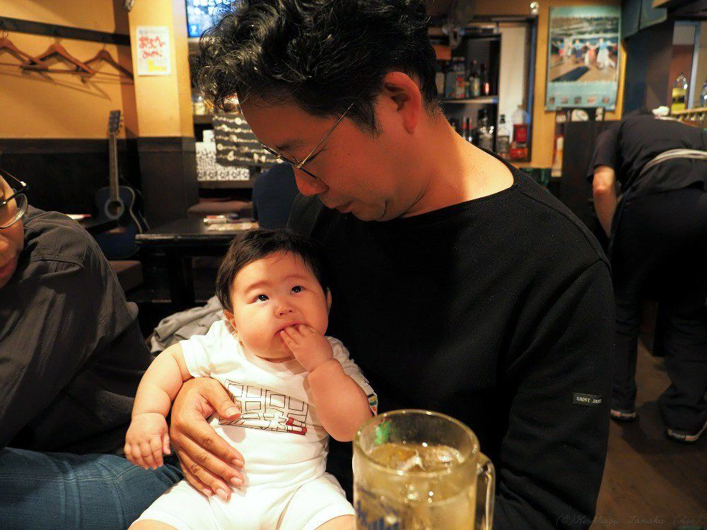 مؤسس الحركة، تاناكا هيروكازو، يحمل الرضيع صاحب نفس الاسم، وهو من مواليد عام 2019. (© تاناكا هيروكازو على اليمين)