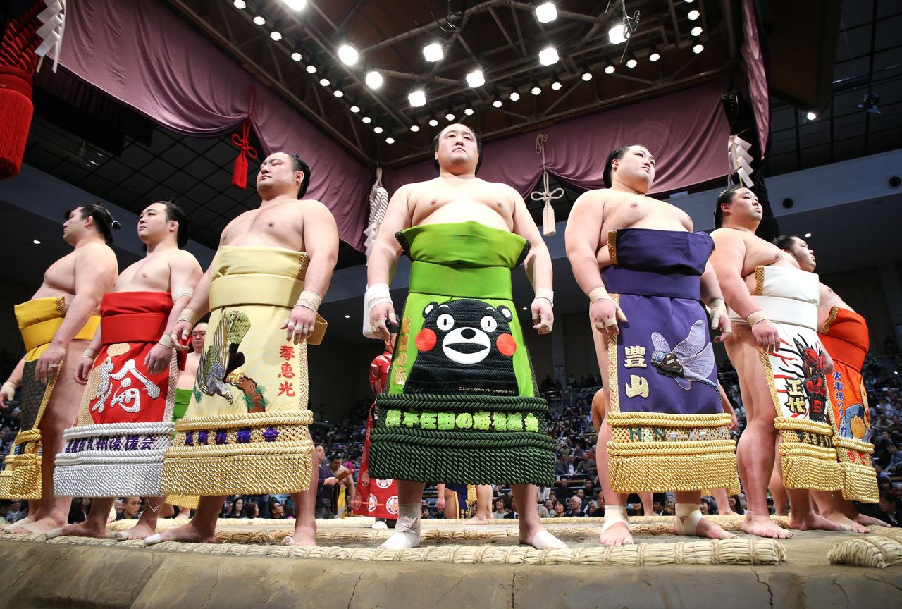 يقف المصارعون في شكل دائري أثناء مراسم دخول الحلبة. يتم أداؤها فقط قبل بدء النزالات في قسمي ˮجوريو“ وˮماكونؤتشي“، وهما القسمان الأعلى في فئات السومو. (© جيجي برس)