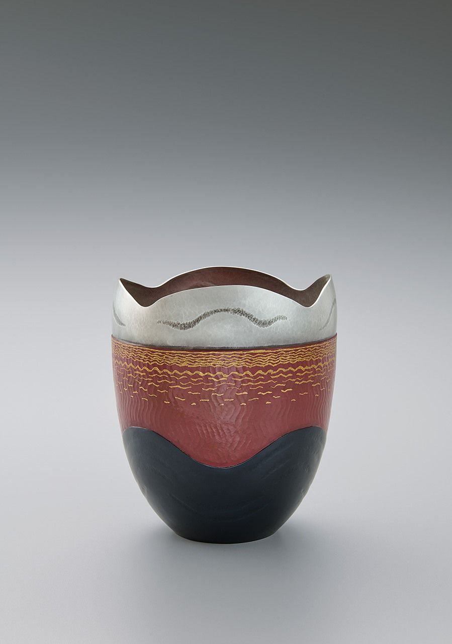 ”البحر الأحمر“، إناء زهور مصنوع من الفضة والنحاس والشاكودو، وقد تم الجمع بين هذه العناصر باستخدام طريقة اللحام الحراري. عُرض في معرض كوغاي الياباني التقليدي التاسع والستين (2022). (بإذن من جمعية كوغاي اليابانية)