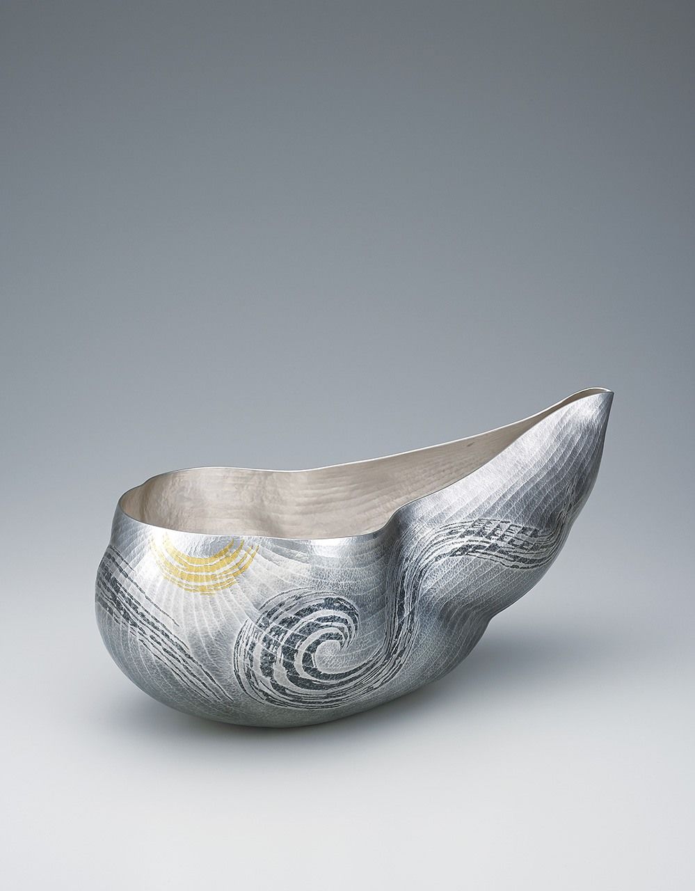 ”السحابة الميمونة“، إناء زهور فضي مصنوع عن طريق التشكيل بالمطرقة. عُرض في معرض كوغاي الياباني التقليدي الخامس والستين (2018). (بإذن من جمعية كوغاي اليابانية)