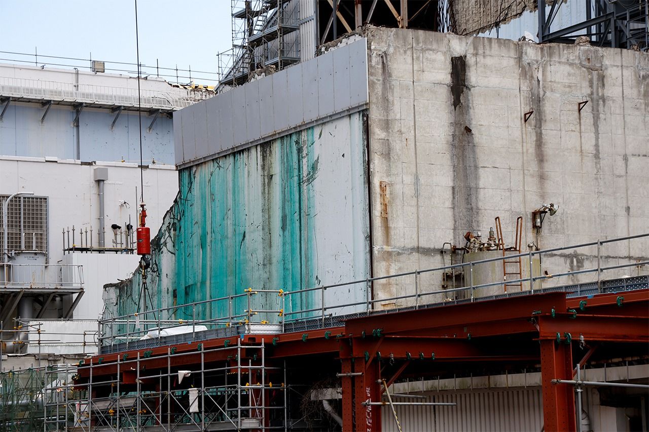 لا تزال المواد الكيميائية التي تم رشها على الوحدة الثالثة لمنع انتشار المواد المُشعة العالقة بالهيكل مرئية. (© هاشينو يوكينوري)