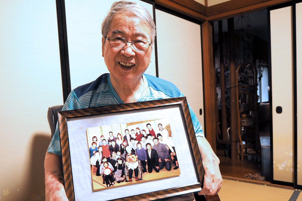إيتشيكاوا هيديؤ يعرض صورة لوالدته إيميكو مع عائلتها بأكملها (© شينوهارا تاداشي).