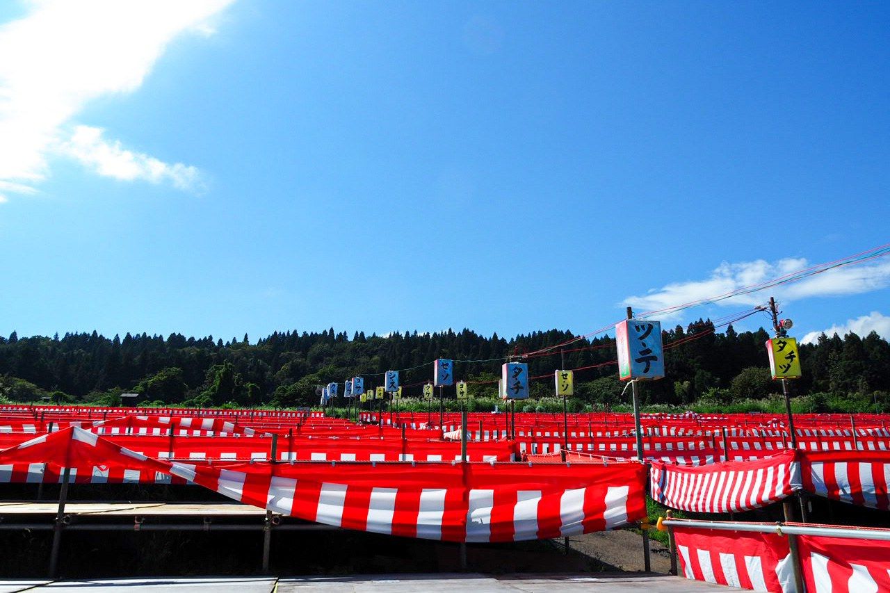 يتم تجهيز مقاعد المهرجان في حقل مفتوح بالقرب من موقع الإطلاق (© شينوهارا تاداشي).