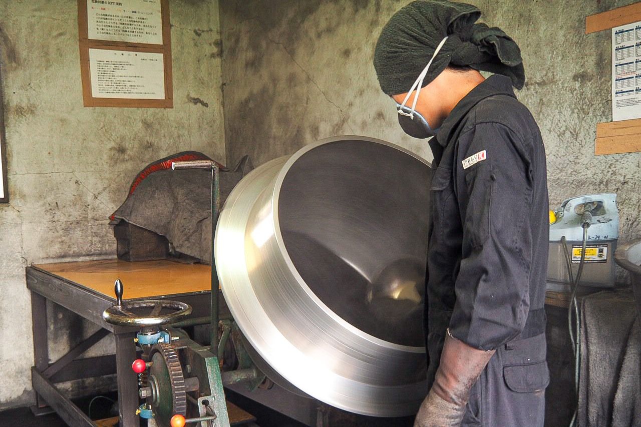 عامل في شركة كاتاكاي للألعاب النارية يصنع مفرقعات على شكل ”نجوم“ تتلألأ بعد تفجير مفرقعة نارية ضخمة (© شينوهارا تاداشي).