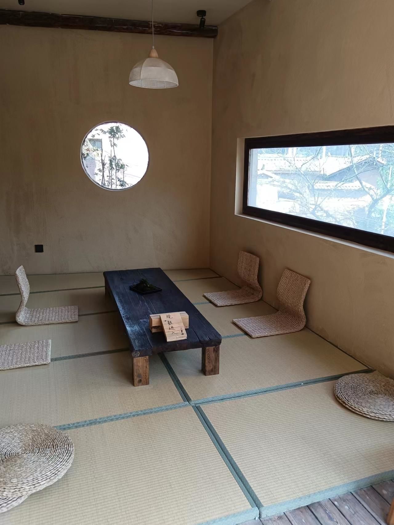 مقهى بطراز ياباني فُرشت أرضيته بالتاتامي ووُضعت فيه طاولة منخفضة ووسادات أرضية في قرية لوجيو في كونمينغ بمقاطعة أونّان الصينية (تصوير: غاو لو)